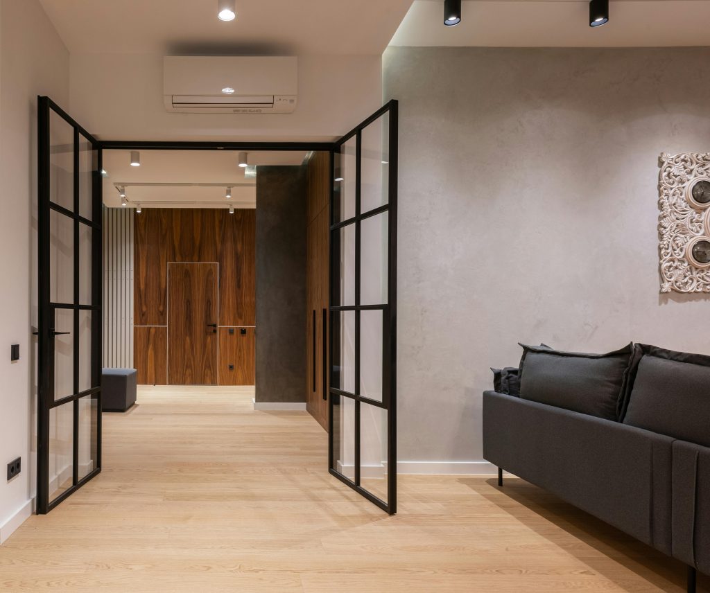 pexels-photo-6585752-6585752 Interior of modern bright house with open doors to hallway near sofa with pillows